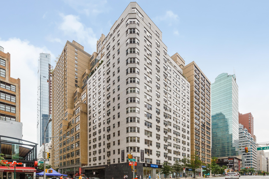 a large white building in a city with tall skyscrapers